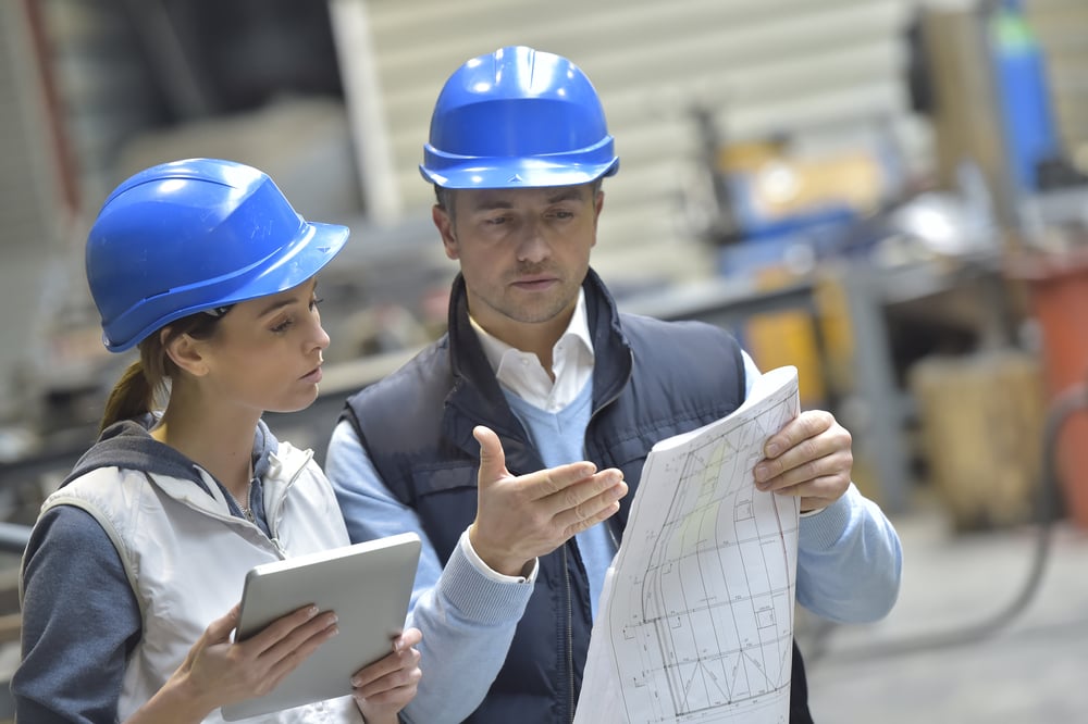 Engineers in mechanical factory reading instructions-1